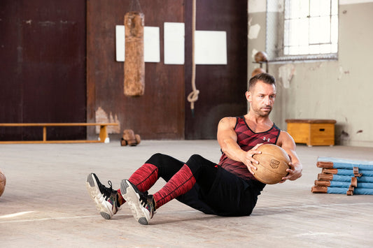 Mann macht einen Russian Twist nach links mit dem ARTZT Vintage Series Medizinball.